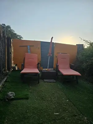two pink chairs sitting on the grass in a yard at Can Marisu, Casita privada in Cabrils