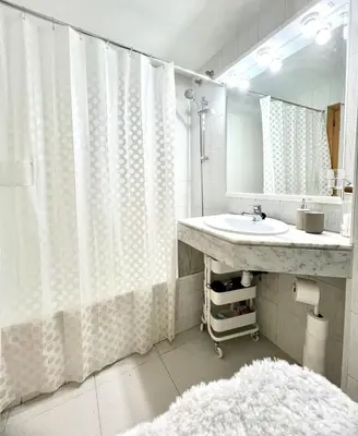a bathroom with a sink and a shower curtain at Acojedor apartamento, centro con patio in Sabadell