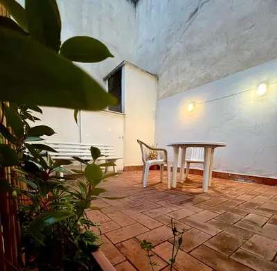 a dining room with a table and a chair at Acojedor apartamento, centro con patio in Sabadell