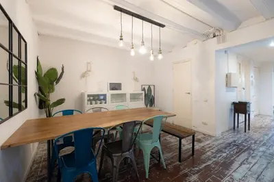 a dining room with a wooden table and chairs at Stay U-nique Roger Llúria in Barcelona