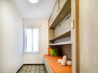 a small bedroom with an orange bed and a window at Horizon Views by Hello Homes Sitges in Sitges