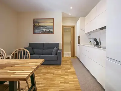 a kitchen and a living room with a couch and a table at Winahost Sabadell Buxeda in Sabadell