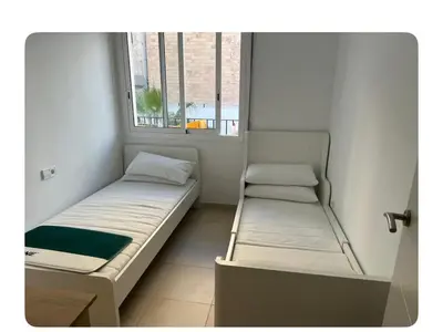 a small room with two beds and a window at Lilli apartment in Sitges