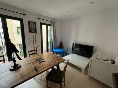 a living room with a wooden table and a television at Lilli apartment in Sitges