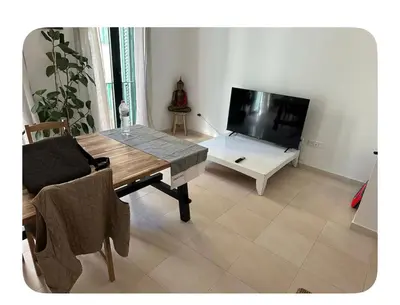 a living room with a table and a flat screen tv at Lilli apartment in Sitges