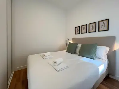 a bedroom with a large white bed with two towels on it at Stay U-nique Apartments Balmes III in Barcelona