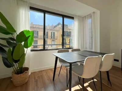 a dining room with a table and chairs and a plant at Stay U-nique Apartments Balmes III in Barcelona