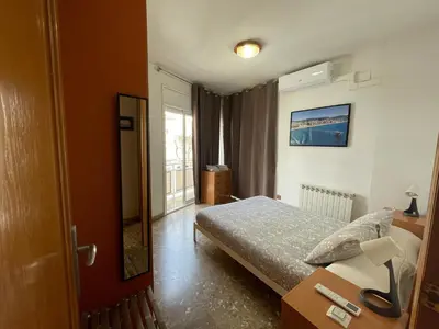 a small bedroom with a bed and a window at Casa la Luna in Badalona