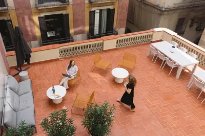 two women sitting on a chair with a laptop at Outsite Barcelona in Barcelona