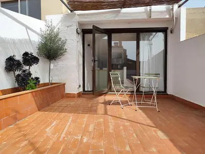 a patio with chairs and a table in a building at Mazi Plaça Gran in Mataró