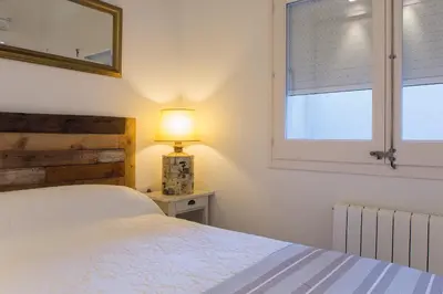 a bedroom with a bed and a lamp and a window at Bright Industrial Loft Barcelona Center in Barcelona