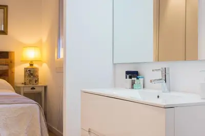 a white bathroom with a sink and a bed at Bright Industrial Loft Barcelona Center in Barcelona