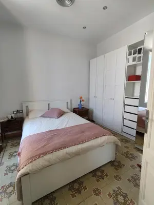 a bedroom with a large bed with white cabinets at Pis històric modernista al centre de Manresa in Manresa