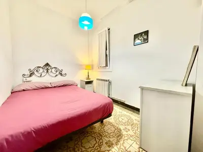 a bedroom with a pink bed and a desk at Bright 3 Bedroom Apartment Central Barcelona in Barcelona