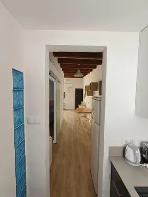 a kitchen and dining room with white walls and wooden floors at Elegant apartment Sagrada Familia in Barcelona