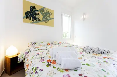 a white bedroom with a bed with towels on it at St. Antoni sky lounge in Barcelona