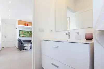 a white kitchen with a sink and a chair at St. Antoni sky lounge in Barcelona