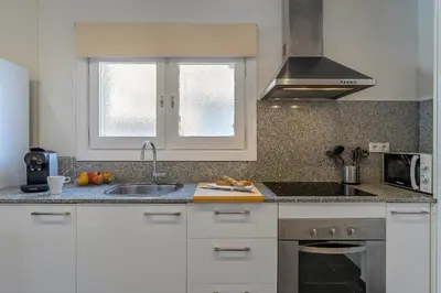 a kitchen with white cabinets and a sink and a stove at 4329 - AB Eixample Centric in Barcelona