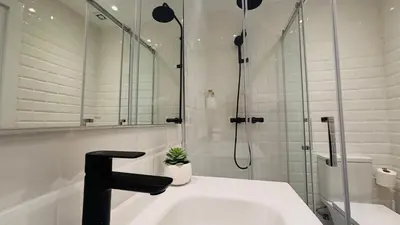a bathroom with a sink and a glass shower at Bajos con encanto by Prestigi in Terrassa