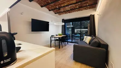 a kitchen and living room with a couch and a table at Bajos con encanto by Prestigi in Terrassa