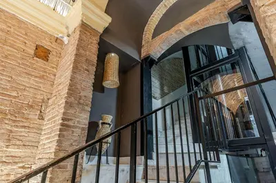 a staircase in a building with a brick wall at Enjoybcn Colon Apartments in Barcelona