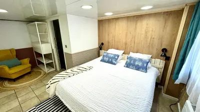 a bedroom with a bed with blue pillows and a yellow chair at Loue Villa à Castelldefels BARCELONE avec piscine, 8 couchages, 7 minutes de la plage in Castelldefels