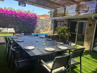 a long table with chairs and glasses on a patio at Loue Villa à Castelldefels BARCELONE avec piscine, 8 couchages, 7 minutes de la plage in Castelldefels
