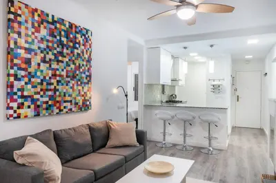 a living room with a couch and a kitchen at Homenfun Barcelona Los Bunkers in Barcelona