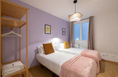 two beds in a room with purple walls and a window at Stay U-nique Apartment Castanyer II in Barcelona