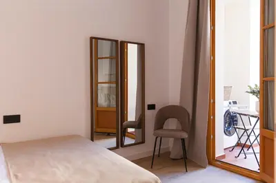 a bedroom with a bed and a chair and a mirror at Barcelona - Gracia P-A in Barcelona