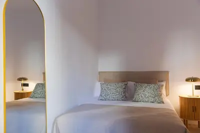 a bedroom with two beds and a mirror at Barcelona - Gracia P-B in Barcelona