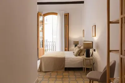 a bedroom with a bed and a table with a lamp at Barcelona - Gracia 1-A in Barcelona