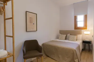 a bedroom with a bed and a chair at Barcelona - Gracia 2-A in Barcelona