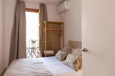a bedroom with a bed with white sheets and a window at Barcelona - Gracia 2-A in Barcelona