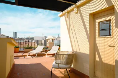 a patio with white chairs and a building at Barcelona - Gracia 5-B in Barcelona