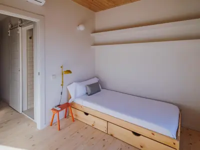 a room with a table and a blue chair at Casa Flor Boutique Mid-term Monthly Rentals in Barcelona
