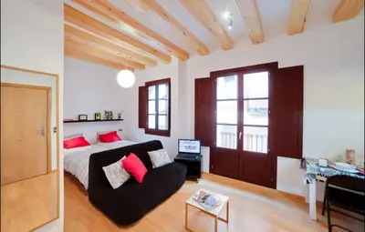 a bedroom with a bed and a couch in a room at Barceloneta Beach 1 in Barcelona