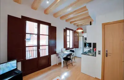 a living room with a door and a kitchen with a table at Barceloneta Beach 1 in Barcelona