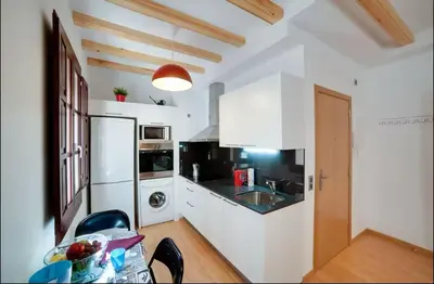 a kitchen with white cabinets and a white refrigerator at Barceloneta Beach 1 in Barcelona