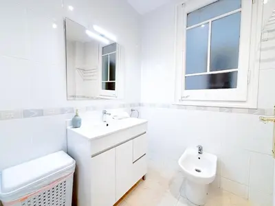 a white bathroom with a sink and a toilet at Bright Modernista Apartment Center Eixample in Barcelona