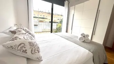 a bedroom with a bed and a large window at Luminoso apartamento by Prestigi in Terrassa