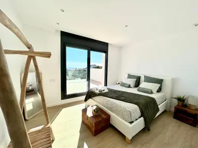a bedroom with a bed and a large window at Les Flors de Cunit Villa Cedra in Cunit