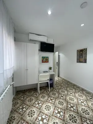 a room with a desk and a table on a tile floor at Hostal Nova Barcelona in Barcelona