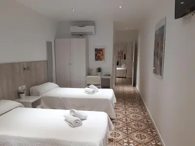 a hotel room with two beds with towels on them at Hostal Nova Barcelona in Barcelona