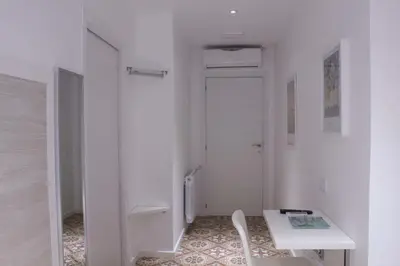 a small white room with a table and a door at Hostal Nova Barcelona in Barcelona
