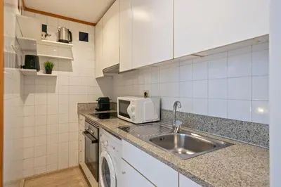 a kitchen with a sink and a microwave at Click&Flat Gran Via Barcelona in Barcelona