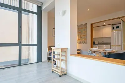 a kitchen and dining room with a large window at Click&Flat Gran Via Barcelona in Barcelona