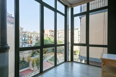 a room with large windows looking out at a city at Click&Flat Gran Via Barcelona in Barcelona