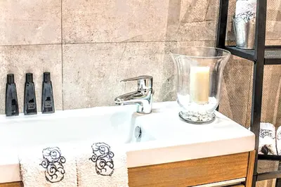 a bathroom sink with a candle in a vase on it at La Rambla spacious 3BR monthly rental - Parsifal in Barcelona