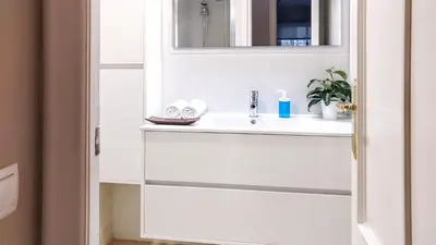 a white bathroom with a sink and a mirror at Gatsby - 3BR Luxury high floor Terrace by Lilla in Barcelona